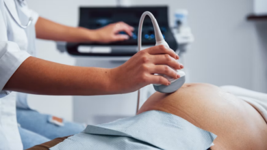 Nurse using handheld ultrasound tech during a patient checkup